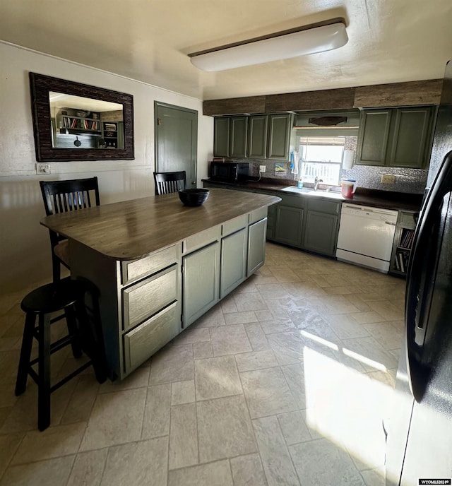 kitchen with tasteful backsplash, butcher block counters, sink, and black appliances