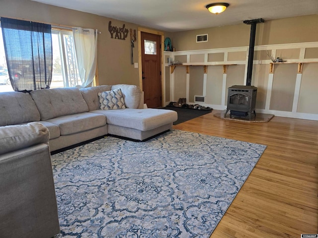 living room featuring wood-type flooring and a wood stove