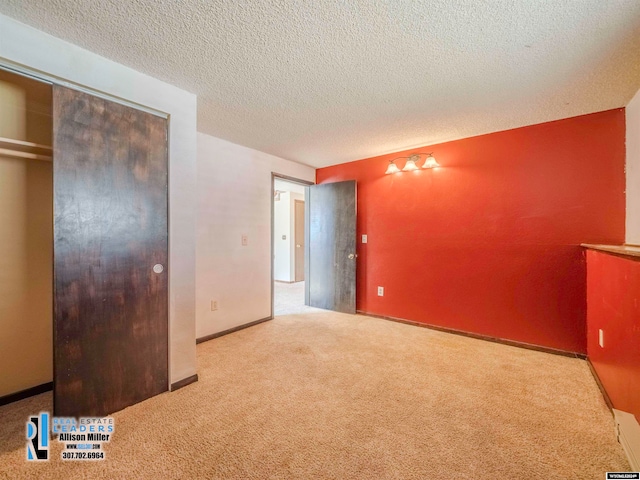 unfurnished bedroom with light carpet, a textured ceiling, and a closet