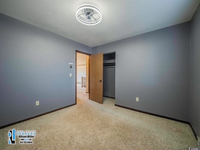 unfurnished bedroom with light colored carpet and a closet