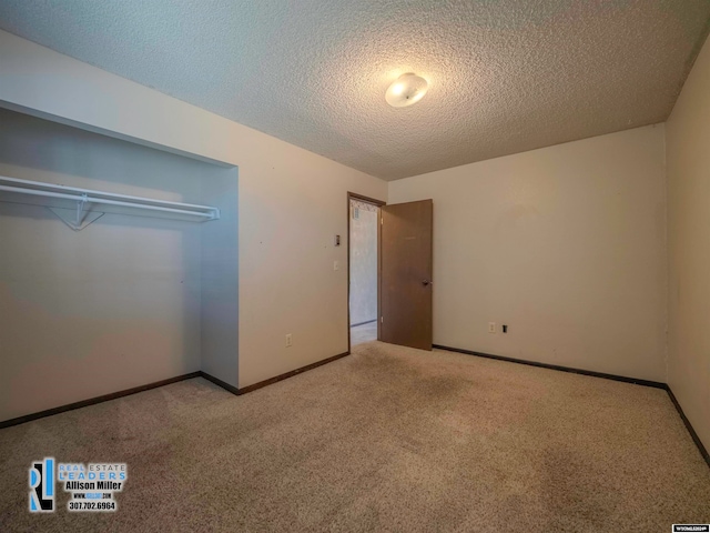 unfurnished bedroom featuring light carpet, a closet, and a textured ceiling