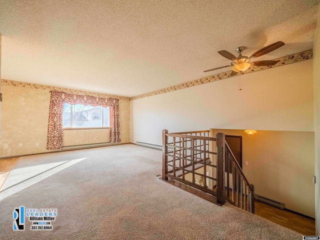 unfurnished room with ceiling fan, wood-type flooring, a textured ceiling, and a baseboard radiator