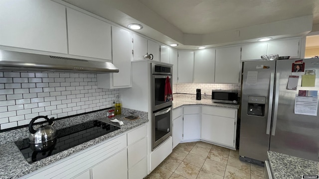 kitchen featuring light stone countertops, appliances with stainless steel finishes, tasteful backsplash, exhaust hood, and white cabinets