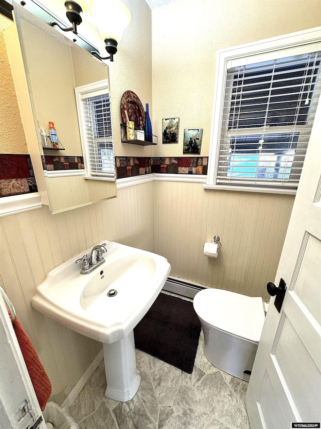 bathroom with toilet and baseboard heating