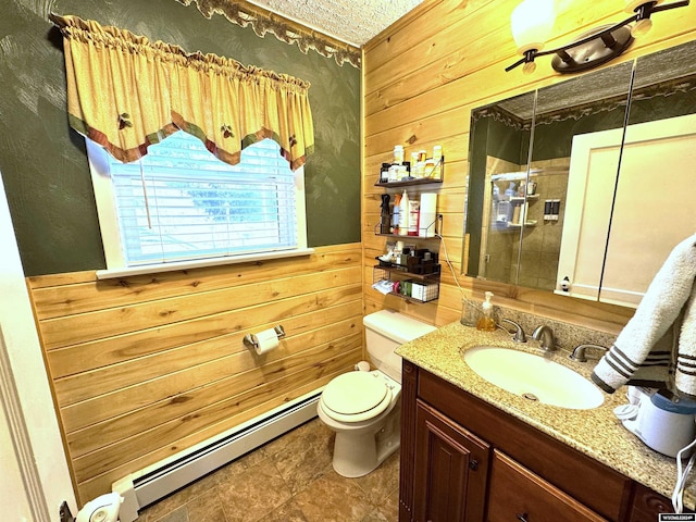 bathroom featuring baseboard heating, wooden walls, vanity, and toilet