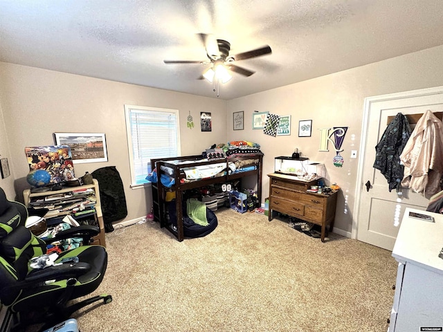 carpeted bedroom featuring ceiling fan and a textured ceiling