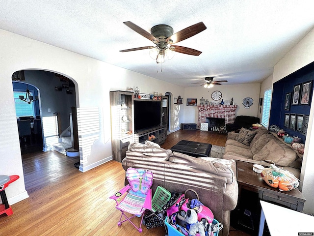 living room featuring hardwood / wood-style flooring, plenty of natural light, ceiling fan, and a textured ceiling