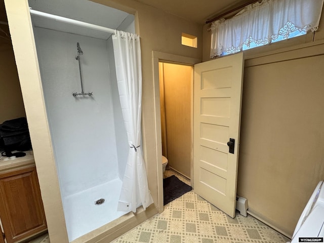 bathroom with curtained shower and toilet