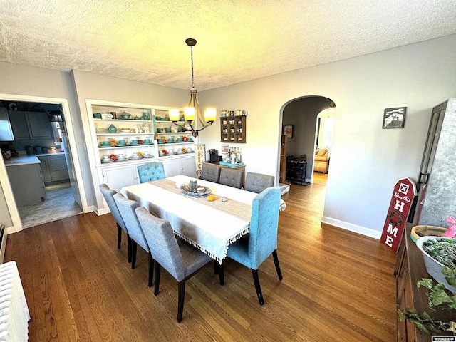 dining area featuring wood-type flooring, a textured ceiling, and an inviting chandelier