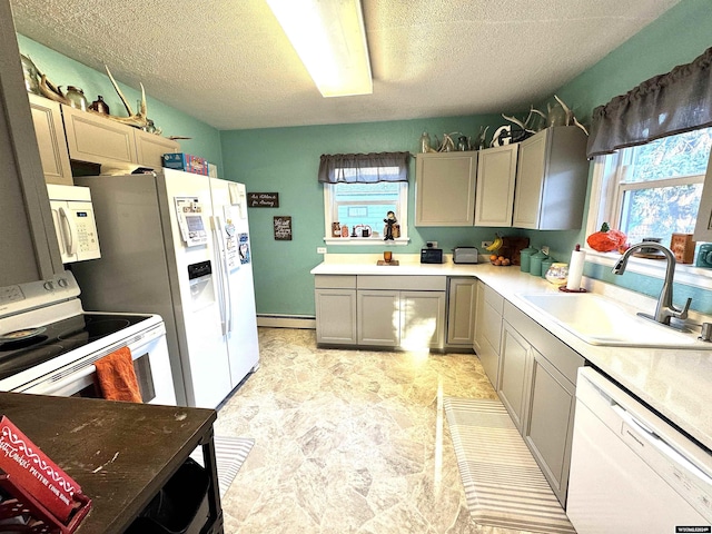 kitchen with a textured ceiling, white appliances, a baseboard heating unit, sink, and gray cabinets