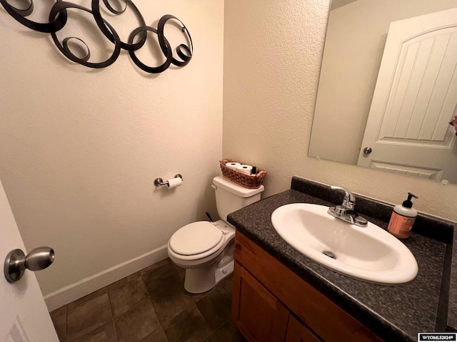 bathroom featuring tile patterned flooring, vanity, and toilet