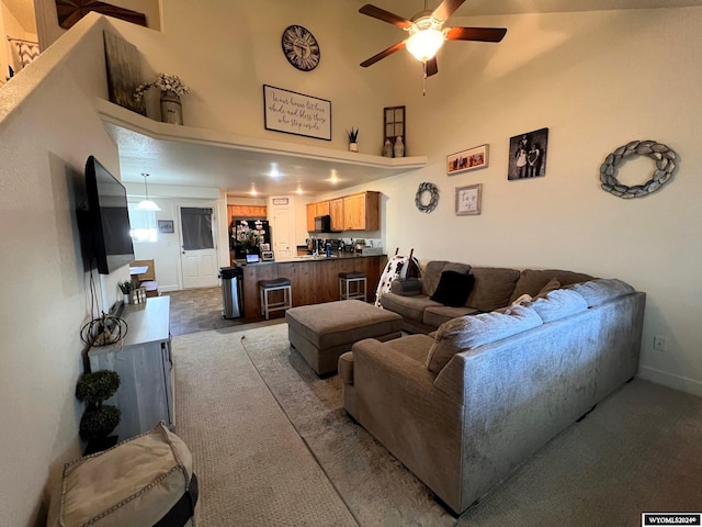 living room featuring ceiling fan and a towering ceiling