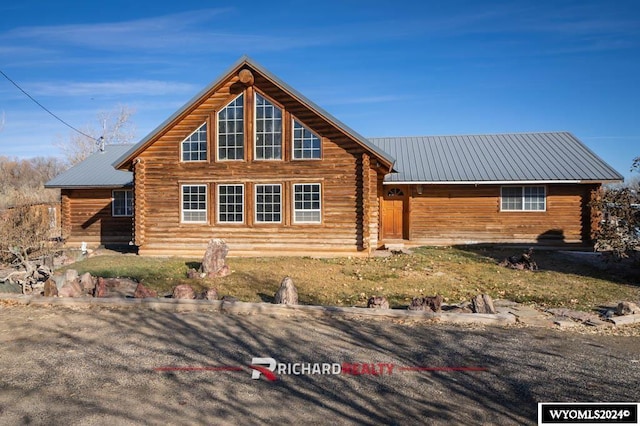 311 Bridge Ave, Worland, WY 82401 - view of home's exterior featuring log siding and a metal roof