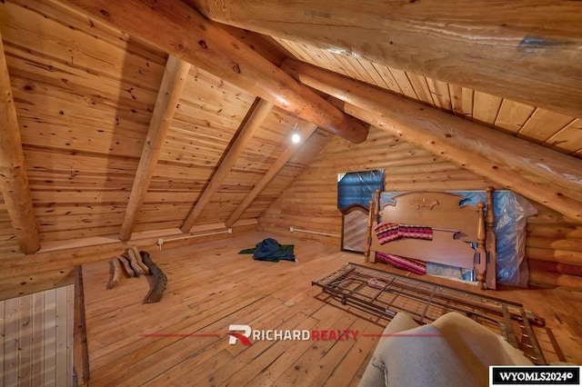 additional living space with lofted ceiling with beams, hardwood / wood-style floors, log walls, and wood ceiling