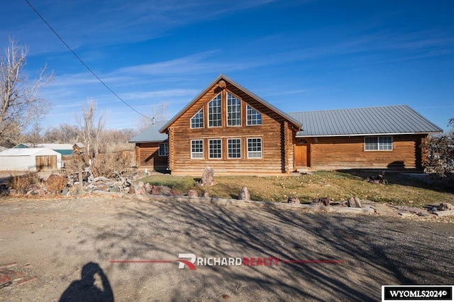 311 Bridge Ave, Worland, WY 82401 - view of front facade featuring log exterior and a metal roof