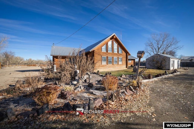 311 Bridge Ave, Worland, WY 82401 - view of home's exterior featuring a metal roof and log exterior