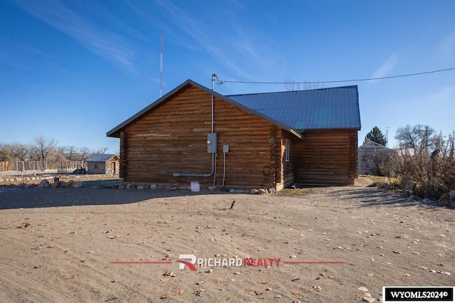 311 Bridge Ave, Worland, WY 82401 - view of home's exterior with a metal roof and log siding