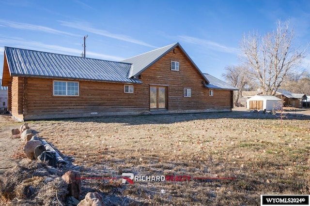 rear view of property with a storage unit