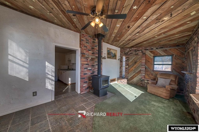 unfurnished living room featuring ceiling fan, vaulted ceiling, a wood stove, and wooden ceiling