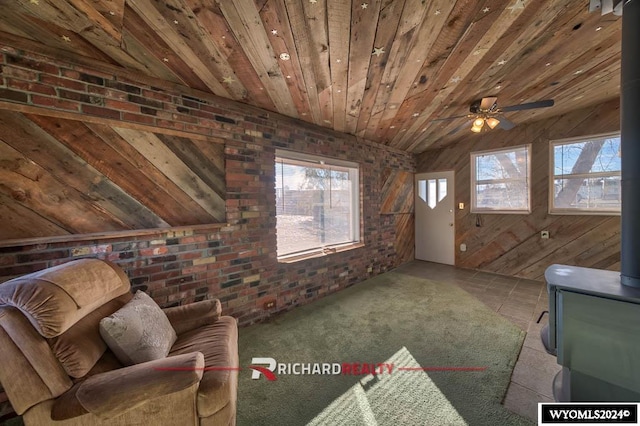 unfurnished living room with wood ceiling, brick wall, ceiling fan, wooden walls, and lofted ceiling