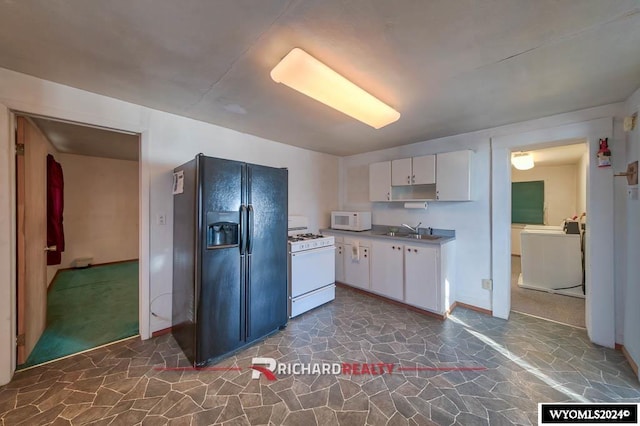 323 Bridge Ave, Worland, WY 82401 - kitchen with white appliances, white cabinetry, stone floors, and washer / clothes dryer
