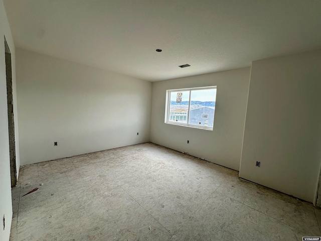 unfurnished room with visible vents