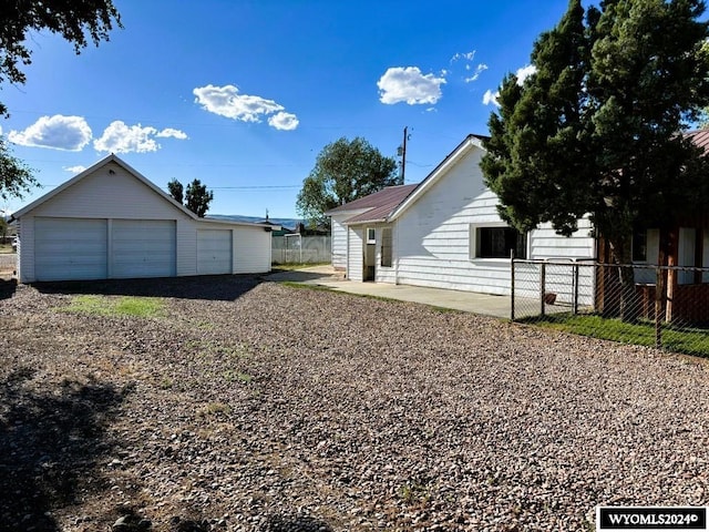 view of yard featuring a garage and an outbuilding