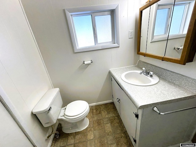 bathroom featuring a wealth of natural light, vanity, and toilet