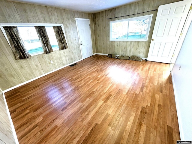 interior space featuring light hardwood / wood-style floors and wood walls