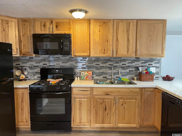 kitchen featuring sink, tasteful backsplash, and black appliances