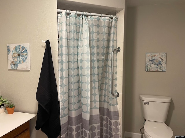 bathroom with vanity, curtained shower, and toilet