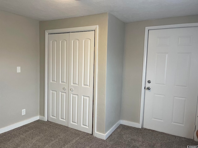 entrance foyer featuring dark carpet and a textured ceiling