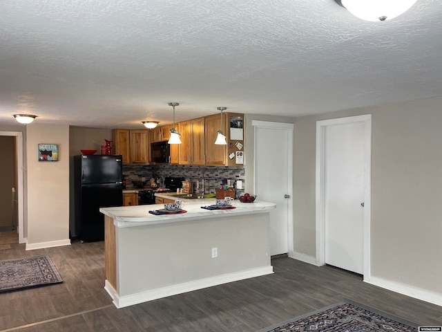 kitchen featuring kitchen peninsula, pendant lighting, dark hardwood / wood-style floors, and black appliances