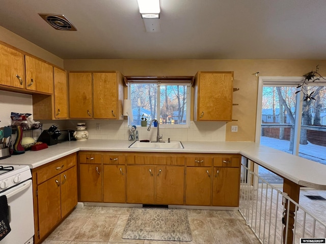 kitchen with white range, tasteful backsplash, and sink