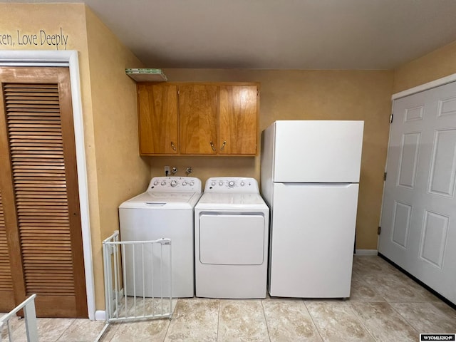 washroom featuring cabinets and washing machine and clothes dryer