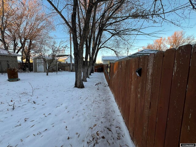 yard covered in snow featuring a storage unit