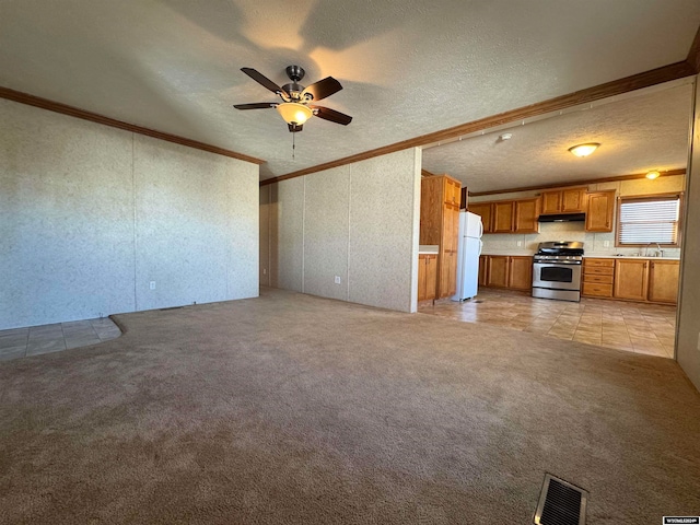 unfurnished living room featuring ceiling fan, crown molding, a textured ceiling, and light carpet