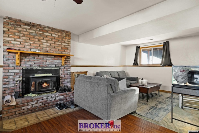 living room featuring a wood stove, ceiling fan, and hardwood / wood-style floors