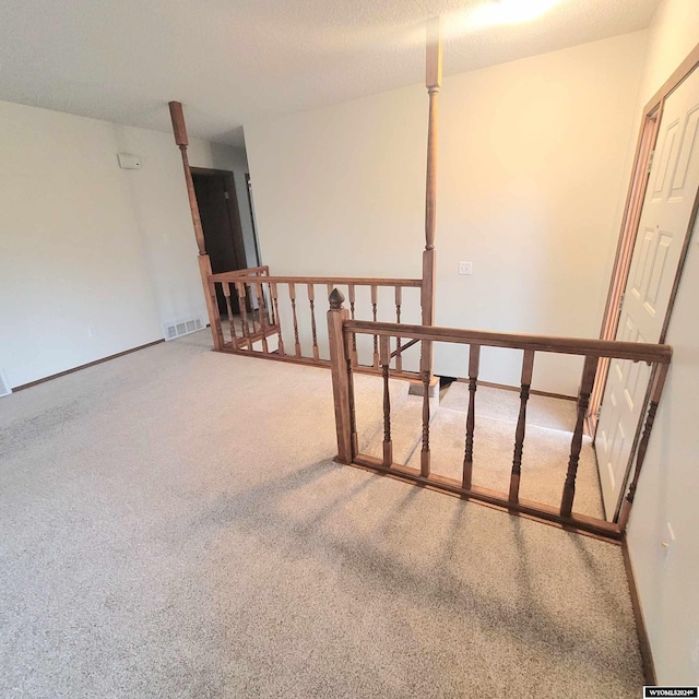 empty room featuring carpet flooring and a textured ceiling