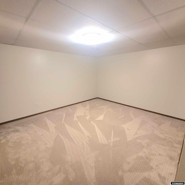 carpeted spare room with a paneled ceiling