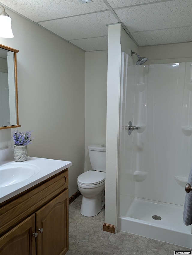 bathroom with vanity, a drop ceiling, toilet, and walk in shower