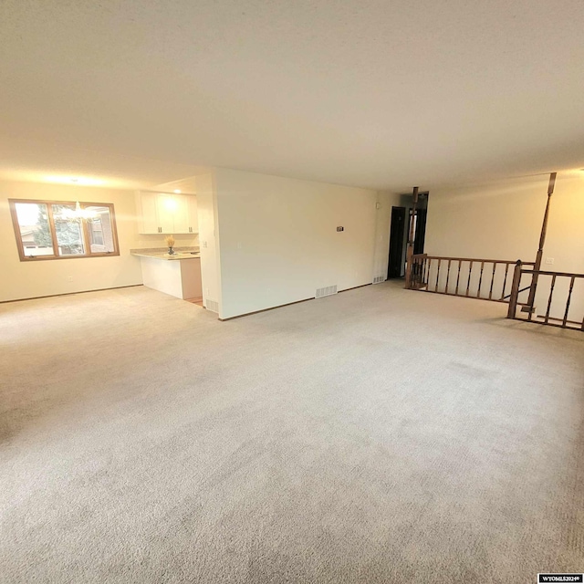 unfurnished living room featuring light colored carpet