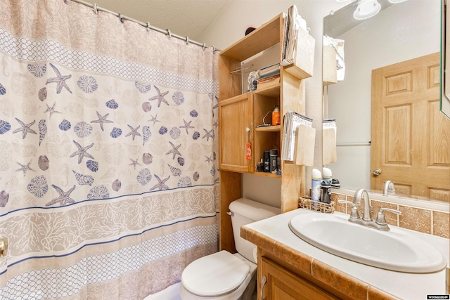 bathroom featuring vanity, toilet, and a textured ceiling