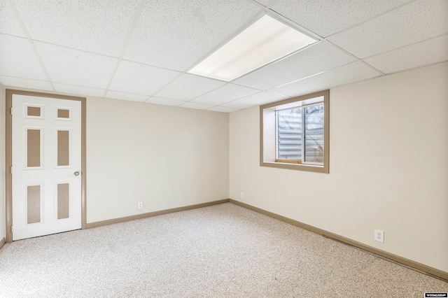 basement with a paneled ceiling and carpet floors