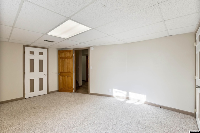 interior space with a paneled ceiling and carpet