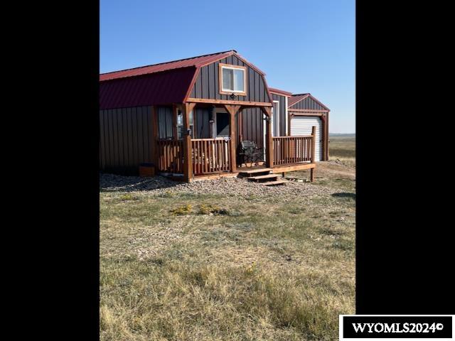 rear view of property featuring an outdoor structure