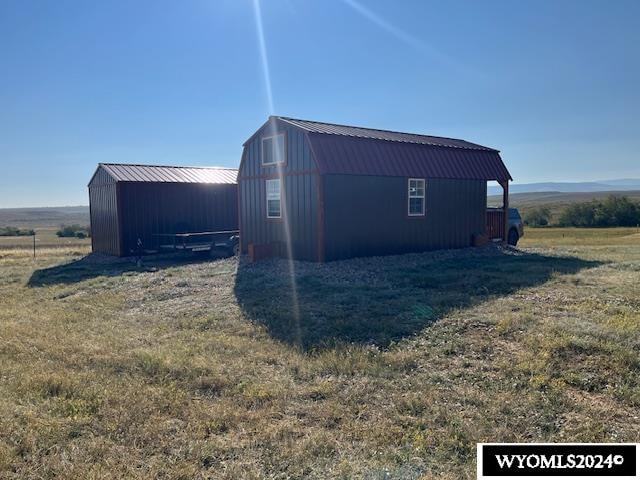 view of home's exterior featuring a yard, a rural view, and an outdoor structure