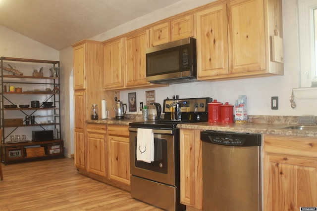 kitchen with light brown cabinets, lofted ceiling, stainless steel appliances, and light hardwood / wood-style floors