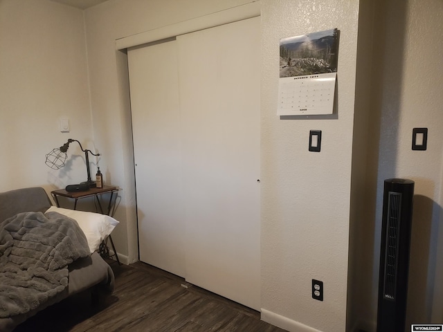 bedroom with dark hardwood / wood-style flooring and a closet