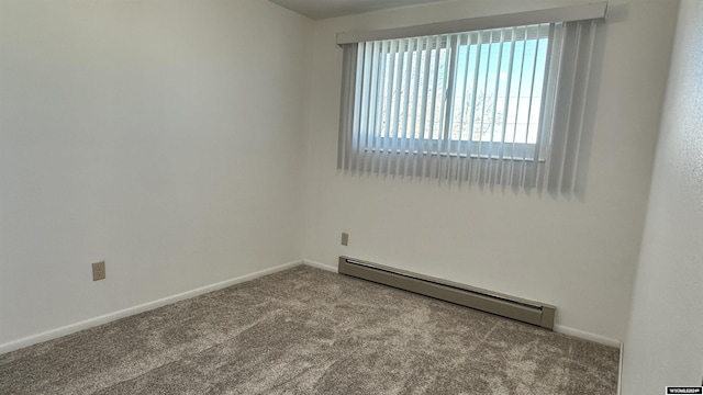 carpeted spare room featuring a baseboard heating unit